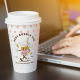 16 oz. White Full Wrap Recyclable Paper Cup displaying "Best Bubble Tea", beside a person working on a laptop, on a wooden table