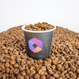 4 oz. Black Multicolor Recyclable Paper Cup with "HexaCore" logo, filled and surrounded by coffee beans, on a white background.