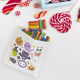 white paper sandwich bag with various cute, Halloween associated characters, filled and surrounded by candy.