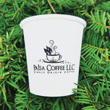 Custom printed 4 oz paper cup with "Paisa Coffee LLC" text and cup image, laying on green pine needles