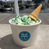 12 oz paper food container, with blue "Sweet Harbour" circle logo, filled with mint chocolate ice cream with a cone and a spoon, on a dock