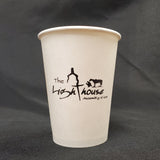 Custom printed 8 oz paper cup with black "The Lighthouse" logo, standing on black cloth