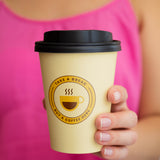 12 oz. Cream Full Wrap Recyclable Paper Cup displaying "Take a break, Come buy a coffee Here", held facing towards the camera